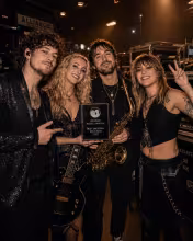 Alliance band members celebrating the Best Emerging Rock Band award backstage