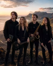Meðlimir Alliance standa í íslensku landslagi og tákna tónlistarferðalagið frá Northern Lights til Higher Ground