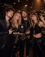 Alliance band members celebrating the Best Emerging Rock Band award backstage